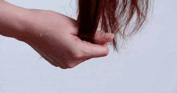 Hand holding excessive hair shedding caused by heat, showing benefits of Vividreamore Velo Essential titanium travel hair dryer with ionic round brush attachment for healthier roots.
