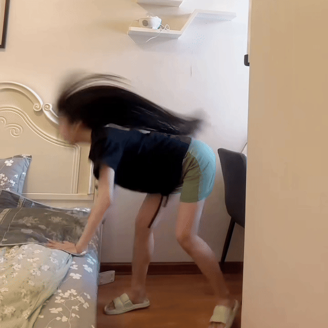 Funny towel-flip hair drying hack at home, showing a girl shaking wet hair onto a towel instead of using the Vividreamore Velo IntelliSense curly hair dryer with ionic high air volume styling