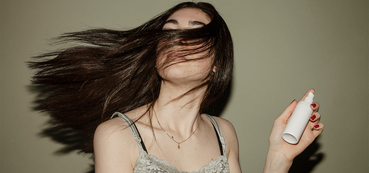 Woman using a quick dry hair spray as an alternative to the Vividreamore Velo IntelliSense ionic titanium travel hair dryer, helping hair dry faster with healthy shine
