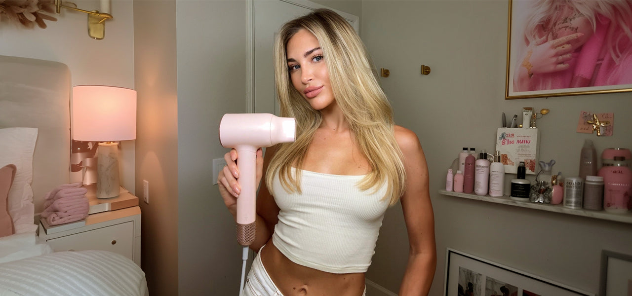 Woman using the Vividreamore Velo IntelliSense hair dryer at home, demonstrating elegant design, smart heat control, and accessible innovation for salon-quality styling.
