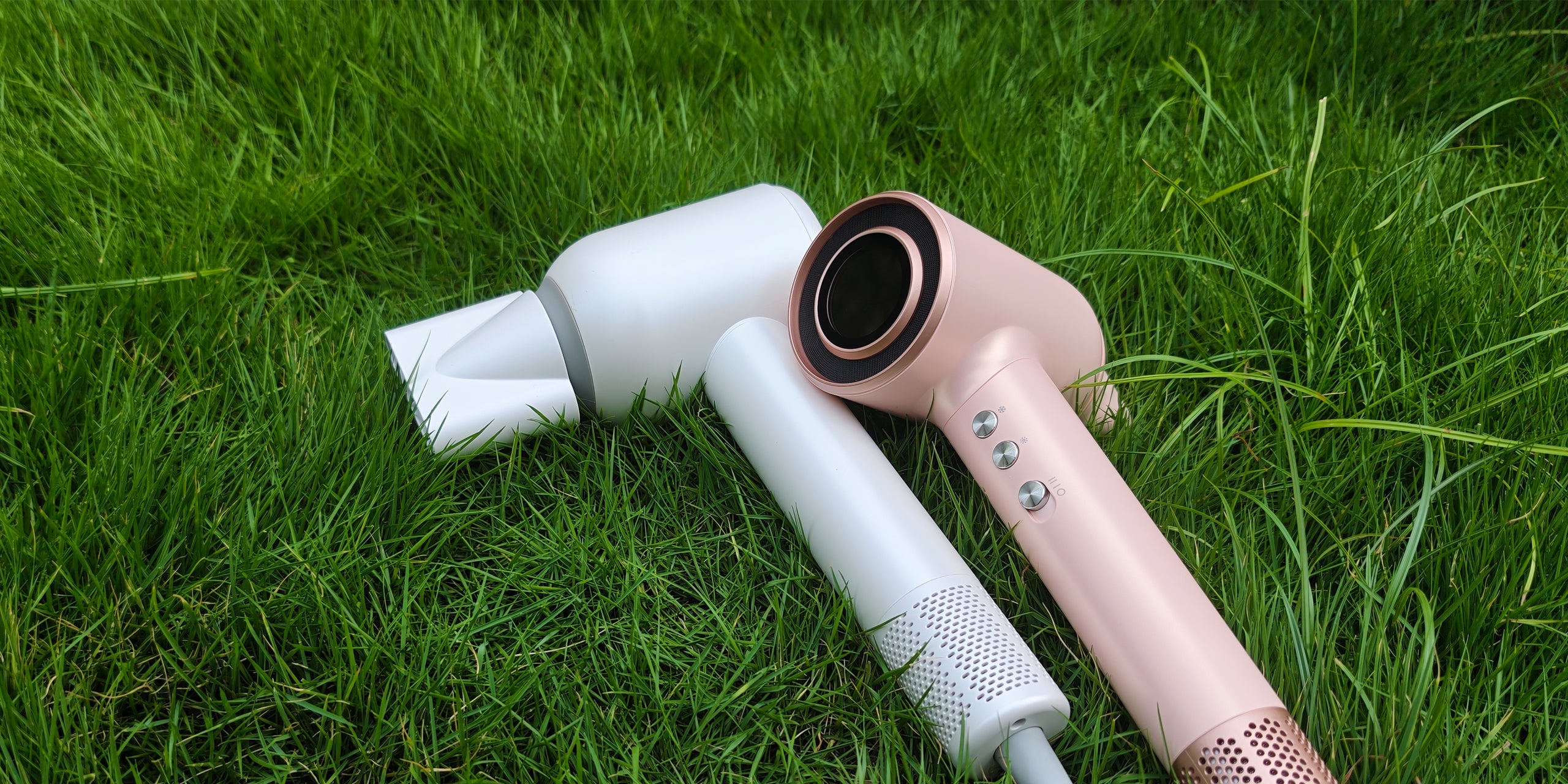 Two Vividreamore high-speed hair dryers, including the Velo IntelliSense and Velo Essential models, placed on grass to highlight smart technology, brushless motors, and heat-control chips for healthier hair.